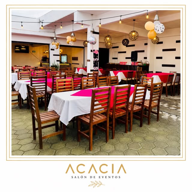 Acacia preparado para un evento con decoración dorada y manteles blancos y rosas